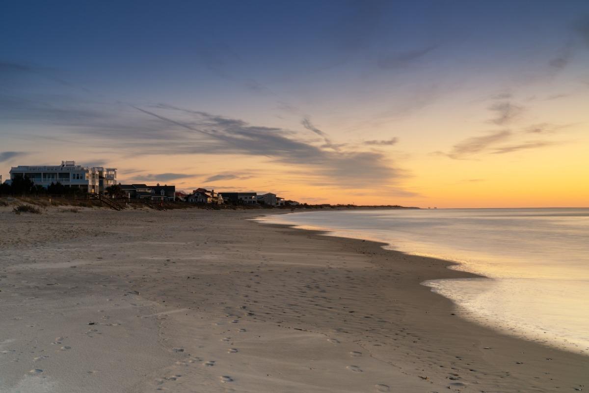 Pawleys Island Beach during sunrise with oceanfront vacation rentals.